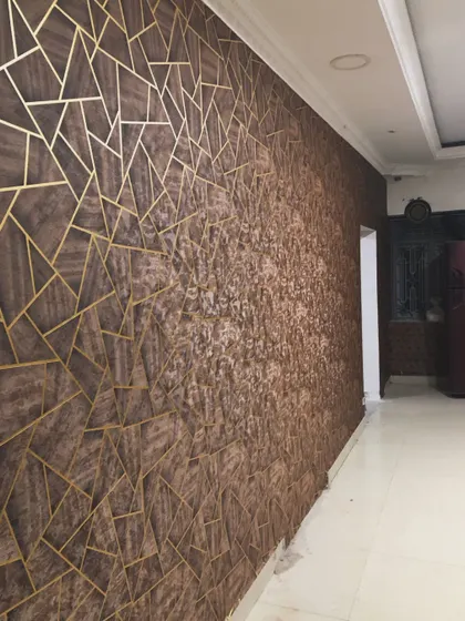 A full wall installation showing a transition from the gold-inlaid wood pattern to a textured brown wallpaper, creating a unique and artistic effect.