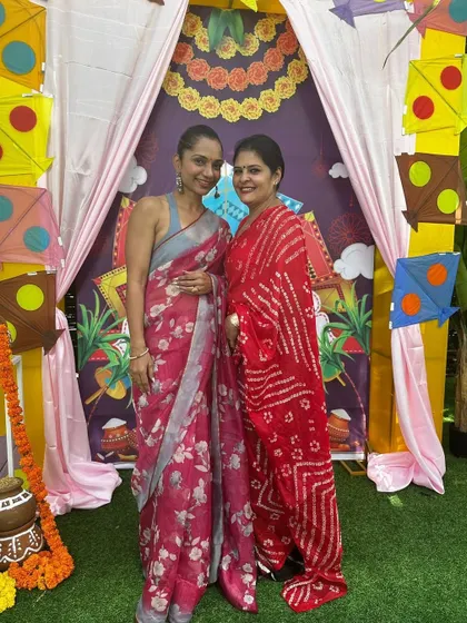 With a fellow guest at a festive gathering. Styling traditional sarees like this printed one is about finding the right balance between heritage and personal flair.
