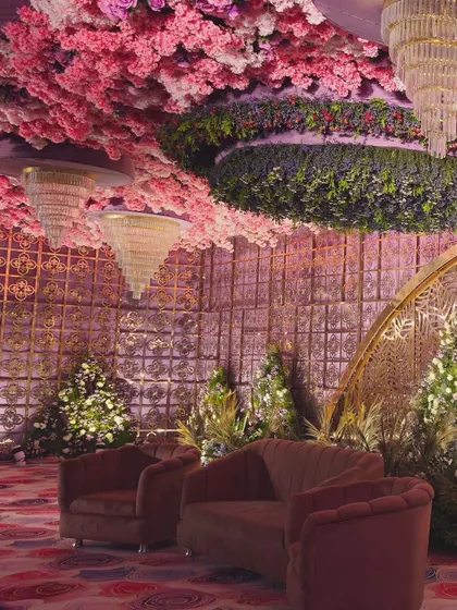 A full view of the magnificent floral ceiling and lounge setup. This kind of immersive decor transforms a venue into a completely different world for your special day.