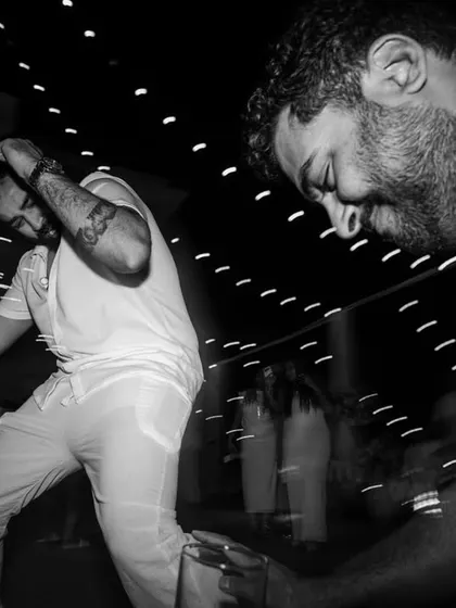 Two friends lost in the music on the dance floor. This candid, motion-filled shot captures the infectious energy and camaraderie of a wedding party.