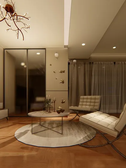 A view of the bedroom's lounge area, featuring classic Barcelona chairs and a marble-topped coffee table. The mirrored wardrobe doors and sheer curtains add to the sense of space and light.