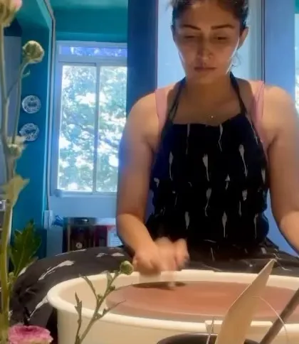 The same student, deep in concentration while throwing. Her journey from client to potter shows how a passion for ceramics can turn into a hands-on skill.