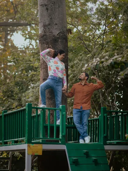 A fun and playful pre-wedding shot where the couple strikes a pose, showing off their muscles in a cute competition.