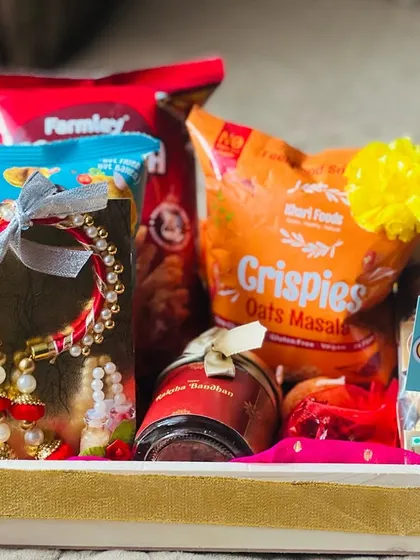 A festive tray hamper for Rakhi, highlighted by a beautiful lumba rakhi set and a variety of snacks.