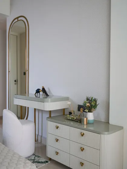 The dedicated dressing vanity with a chest of drawers in the sage green master bedroom, offering well-integrated storage that doesn’t compromise on style.