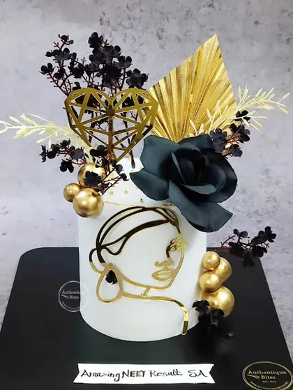 A striking black and gold floral cake for a woman of substance. This design uses a minimalist face outline, black roses, and gold accents to create a piece of modern art.