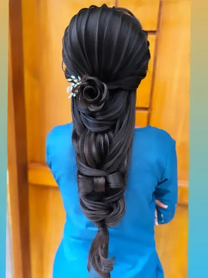 An example of the advanced techniques I teach, this intricate braid features a sculpted hair rose and a detailed hair bow. This style demonstrates a high level of artistry, perfect for creating a unique statement look.