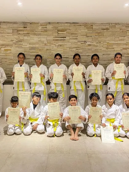 Our youngest karateka from the Prestige Falcon City dojo are thrilled after their very first belt exam, proudly holding their hard-earned yellow belt certificates.