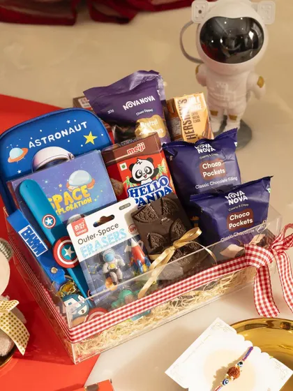A Rakhi gift designed for a little brother who loves space. This hamper is filled with an astronaut stationery box, a colouring book, fun erasers, and lots of his favourite treats.