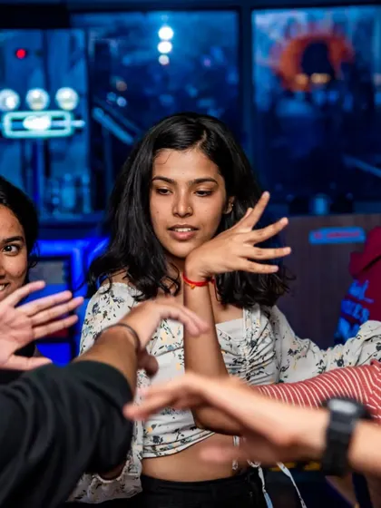 A close-up of friends dancing together. The focus is on the interaction and the shared joy of the moment.