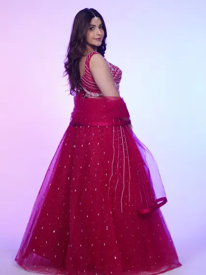 A back view of the hot pink lehenga, highlighting the simple tie-up detail and the flow of the tulle skirt.