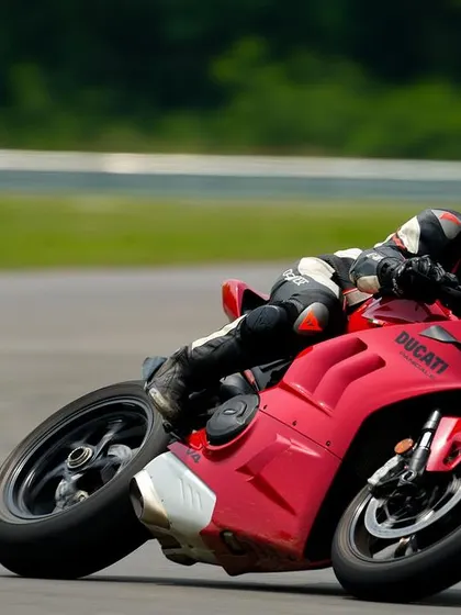Another shot of the red Panigale V4, this time from a different angle, highlighting the rider's focused posture and the bike's aggressive stance.