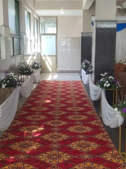 The aisle leading to the stage at a Half Saree event, lined with floral arrangements on stands.