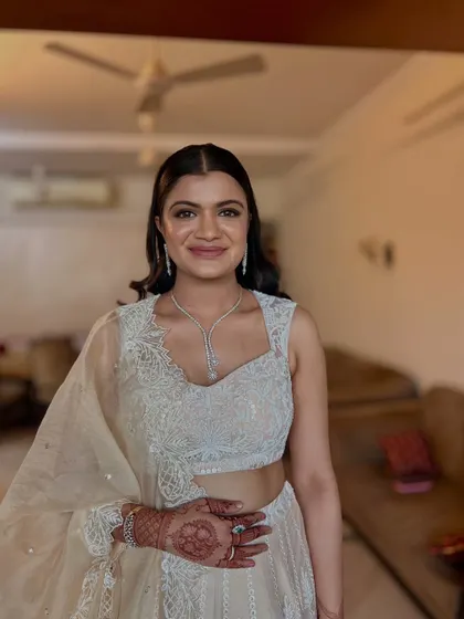 The hair is styled with a clean center part and tucked neatly behind the ears, allowing her diamond jewelry to stand out.