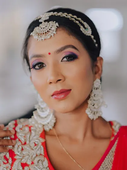 A classic beauty shot. The composition is tight and focused, capturing her flawless skin, elegant jewelry, and confident gaze.