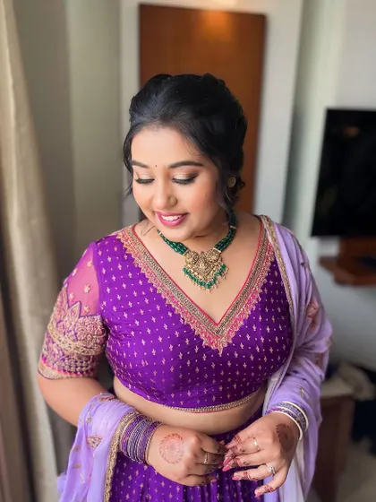 Bhavana looking lovely in a purple lehenga for her event. The makeup is soft and glowing, with a focus on her eyes.