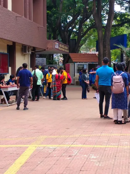 A wide shot of the job fair, with volunteers assisting candidates at the registration desk. Our goal is to create a seamless and supportive environment.