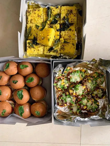A party order featuring boxes of Khaman Dhokla, Mini Veggie Burgers, and Mini Pizzas.
