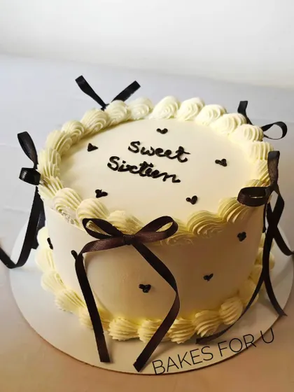 "Sweet Sixteen." A classic vintage-style cake with delicate piping and brown ribbon bows, perfect for celebrating a 16th birthday.