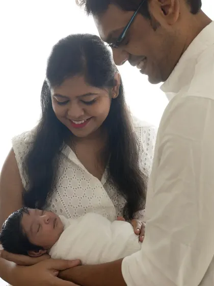 A color version of the classic newborn family portrait. The parents' loving gaze and the baby's peaceful sleep are the heart of this image.