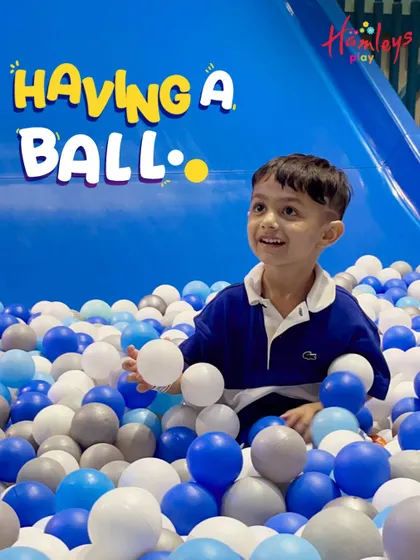 Having a ball is what it's all about! This little one is enjoying the simple pleasure of our massive ball pit, a favorite activity for children of all ages.