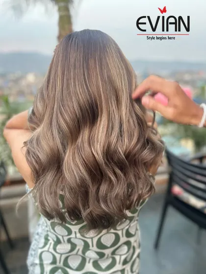 A stunning view of an ash-blonde balayage with a beautiful outdoor backdrop. The natural light really makes the cool tones pop.