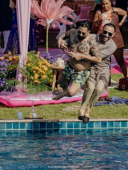 Two guests joyfully jump into the pool during a fun-filled pre-wedding party at the Sheraton Hua Hin, Thailand.