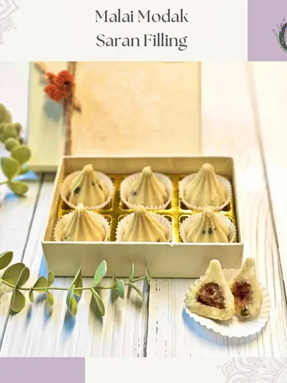 Our Malai Modak with a traditional 'saran' filling. These sweets combine classic flavors with an elegant presentation.