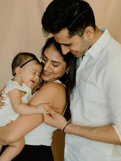 Watching your little family bloom is a magical feeling. This tender portrait captures the love and joy of new parents with their baby girl.