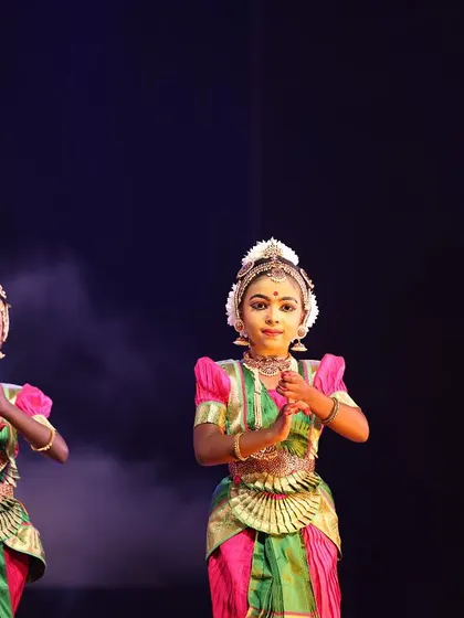 A quartet of young dancers in perfect unison, their identical postures and expressions reflecting their dedicated practice and discipline.