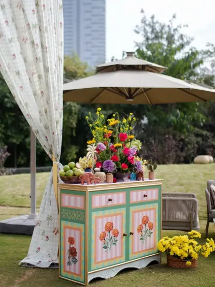 We believe every corner should be beautiful. This hand-painted cabinet, topped with a vibrant floral arrangement, served as a charming and functional decor piece.