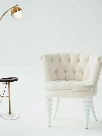 A svelte antique brass floor lamp that combines lighting with modern technology. This piece features a built-in wireless charger and USB port on its wooden tray, set on a sturdy marble base, making it the perfect smart addition to your living room.