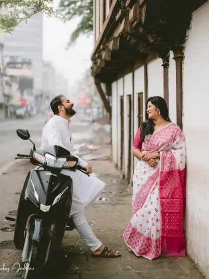 Sharing a laugh on a city street. This candid shot of Chaitrali and Parth with a scooter adds a touch of everyday charm and personality to their pre-wedding album.