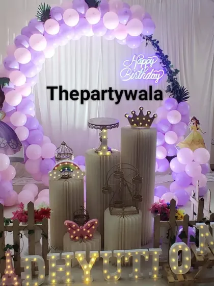A Sofia the First theme with a purple and pink balloon arch and a 'Happy Birthday' neon sign.