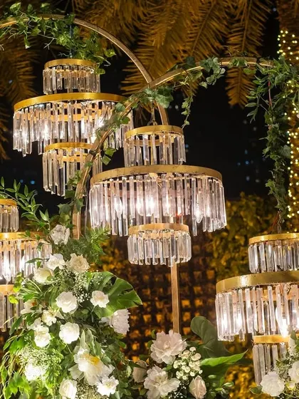 A close-up of the custom-made crystal light fixtures, which were designed to look like miniature chandeliers, adding a touch of glamour to the floral backdrop.