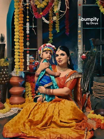 A full portrait of mother and son as Yashoda and Krishna, showcasing the beautiful traditional attire and the vibrant festive setup.