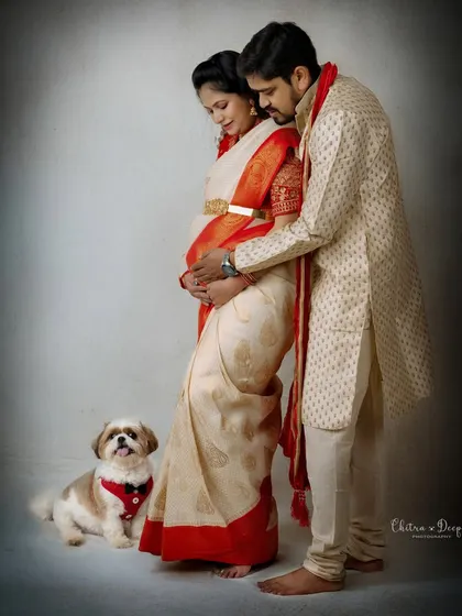 A loving portrait of a couple in traditional wear, joined by their adorable pet. This shot is a perfect blend of tradition and family love.