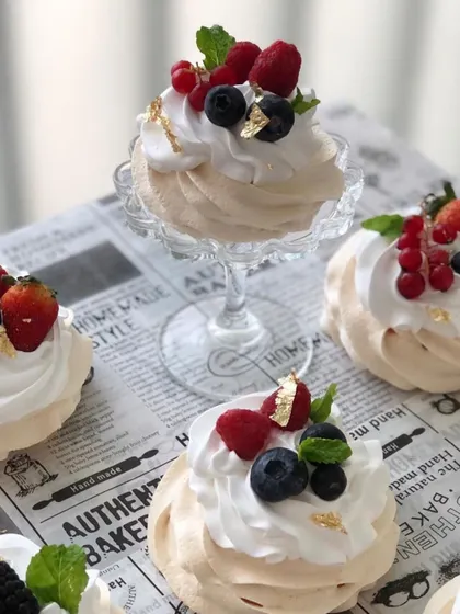 Light and airy pavlovas topped with fresh mixed berries and a touch of gold leaf. A beautiful and gluten-free dessert option.