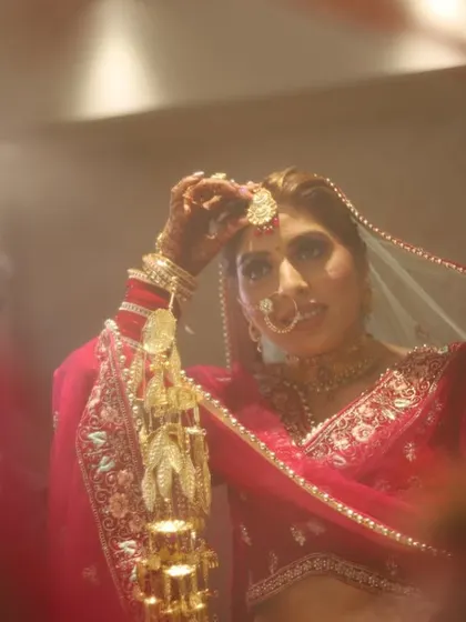 A reflective shot of the bride getting ready, captured through a mirror for a creative effect.