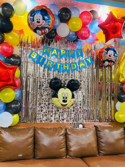 Another angle of the Mickey Mouse themed 4th birthday party, showing the full balloon and foil curtain backdrop.