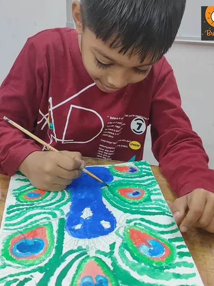 A student carefully paints a peacock, focusing on the intricate details of its feathers. This exercise in observation and detail is great for building artistic skills.