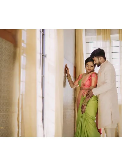 An intimate moment from an engagement. The bride-to-be looks serene in a light green saree paired with a contrasting pink blouse.