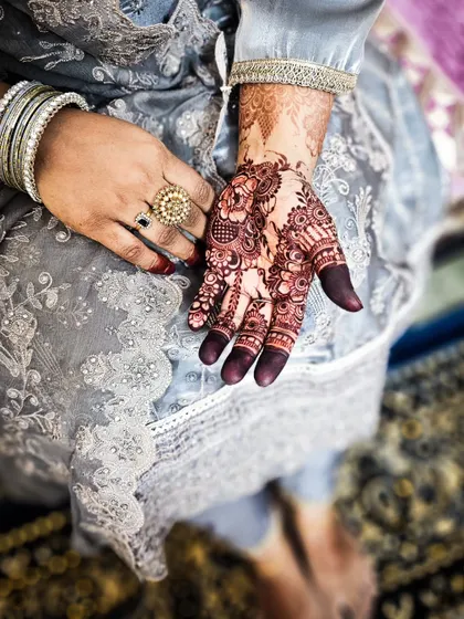 A full-hand design with a rich, dark stain. The filled fingertips are a traditional touch that many of my clients love for festive occasions.