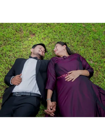 A creative overhead shot of the couple lying on the grass, sharing a look of love. This perspective offers a unique and intimate view of their connection.