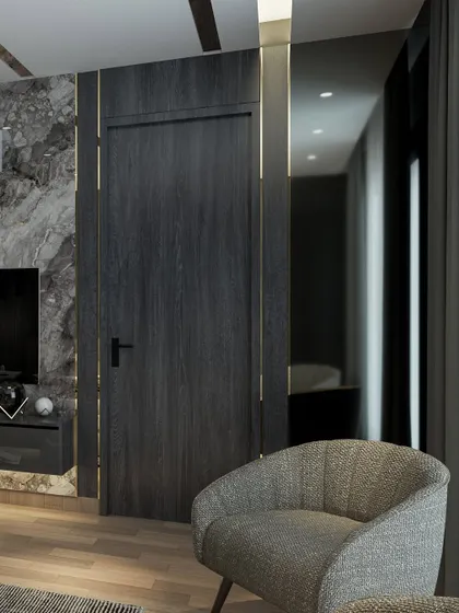 Another view of the moody and luxurious bedroom, showing how the mirrored wall reflects light and makes the space feel larger. The comfortable armchair creates a perfect little nook for reading or relaxing.