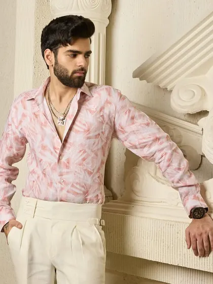 A full look at the pink patterned linen shirt tucked into cream pleated trousers. This outfit combines comfort with modern charisma for a sharp, confident style.