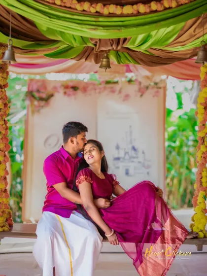 A playful and romantic pre-wedding moment on a swing. The colorful decorations add a festive and joyful feel to the scene.