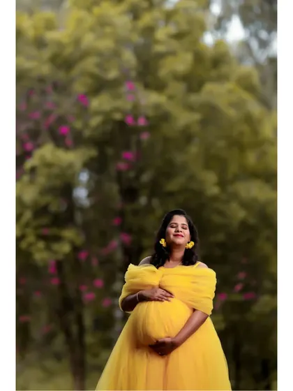 A close-up shot capturing the radiant glow of a mom-to-be in our yellow off-shoulder maternity gown. The soft netting drapes elegantly for a flattering look.