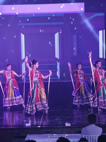 The dancers use dandiya sticks to create rhythmic patterns in this energetic folk dance number.