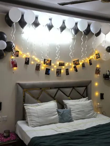The bedroom part of the surprise, featuring a wall of photos illuminated by fairy lights and surrounded by balloons.